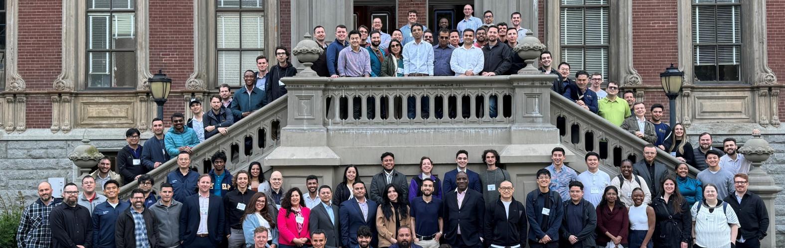 A large group of MICS students pose in front of South Hall at the spring 2024 on-campus immersion