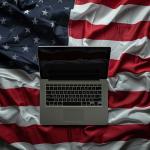 Close-up of laptop on American flag (AI-generated image)