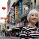 photo of Judy Yung standing in front of a street in San Francisco Chinatown