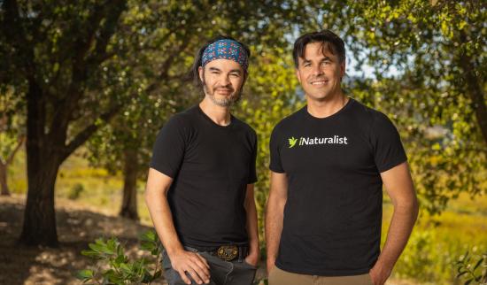 two men standing in the trees