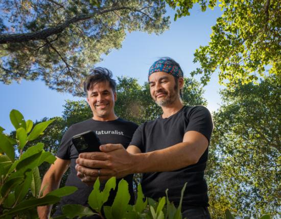 two men smiling at a phone 