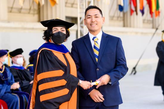 man in blue suit holding diploma