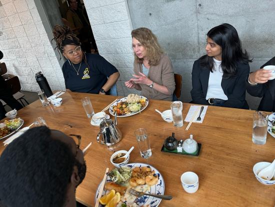 students talk to interim dean Hearst at a restaurant table