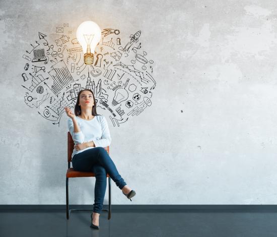 A woman sitting in a chair with an illustration of imaginative thought and a light bulb above her head